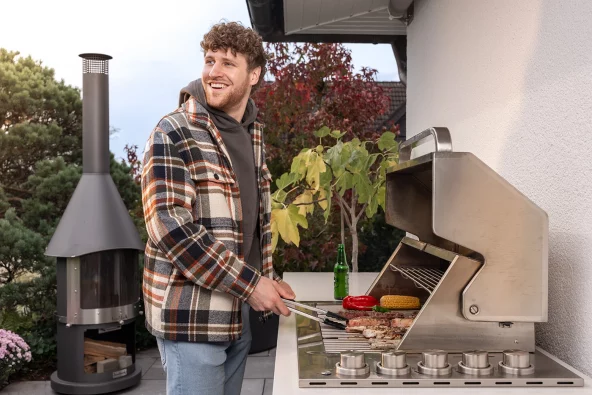 ein junger Mann grillt an der Outdoorküche Bradford