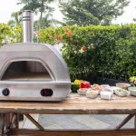Pizzaofen X1 vor blühender Hecke