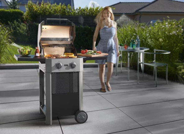 E-Grill mit Grillgut im Garten