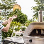 Junger Mann formt den Pizzateig