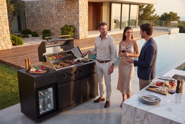 zwei Männer und eine Frau grillen und unterhalten sich an der Outdoorküche Dublin